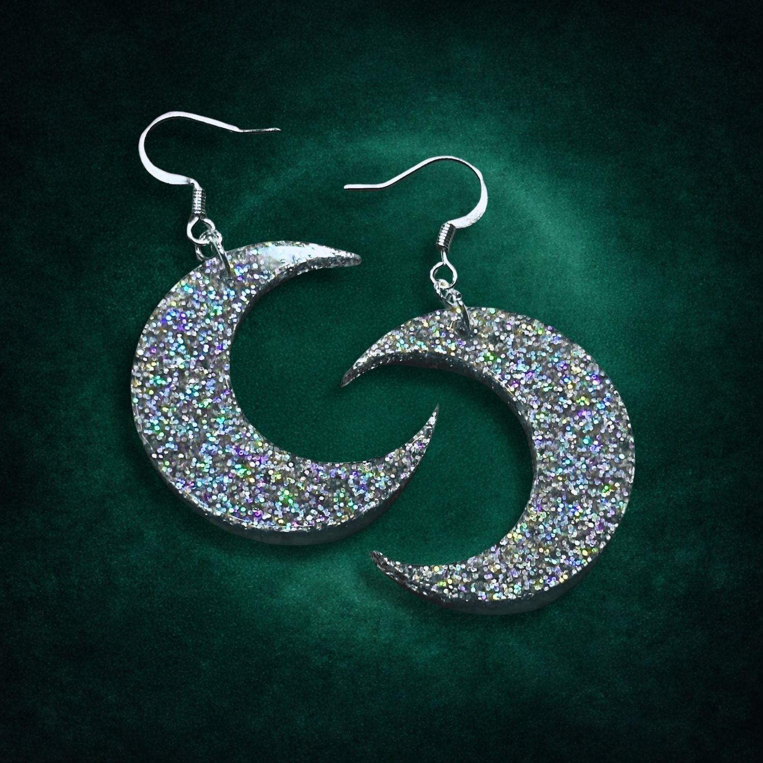Crescent moon earrings on a green background