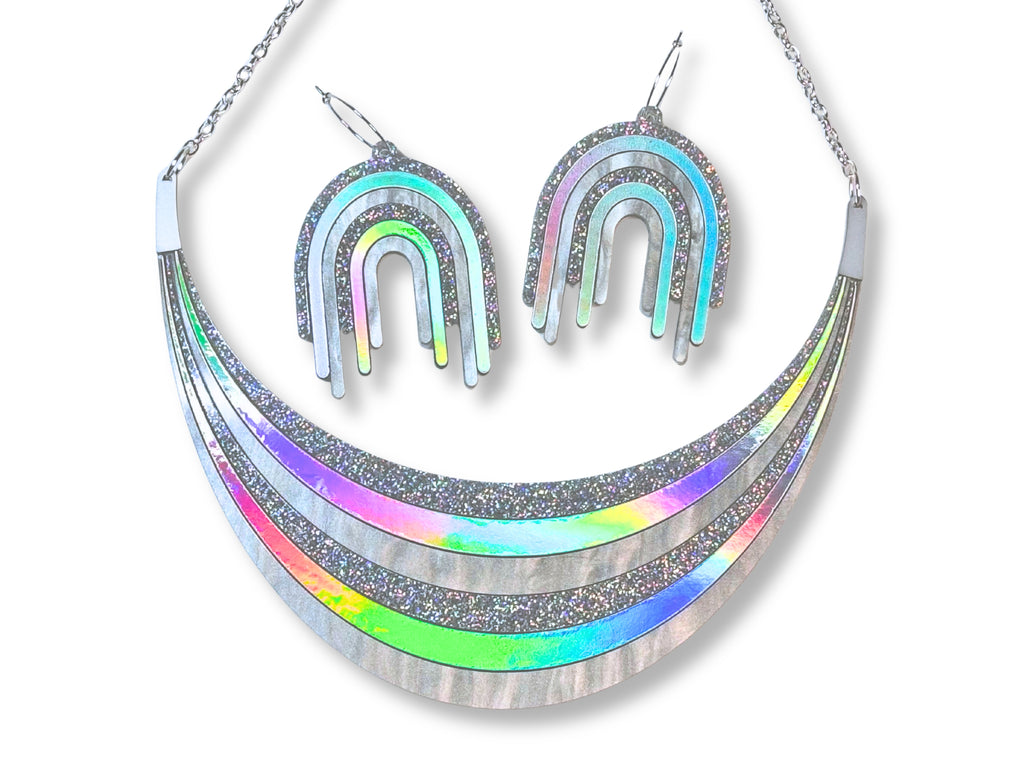 Full Spectrum Rebel Disco Prism jewelry set with silver holographic arc necklace and matching rainbow drip earrings.