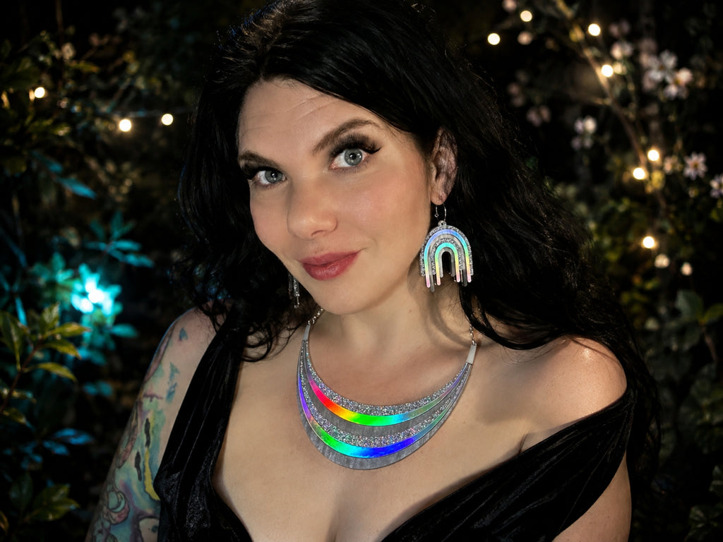 Model wearing the Full Spectrum Rebel Disco Prism necklace and earrings with silver holographic rainbow details.