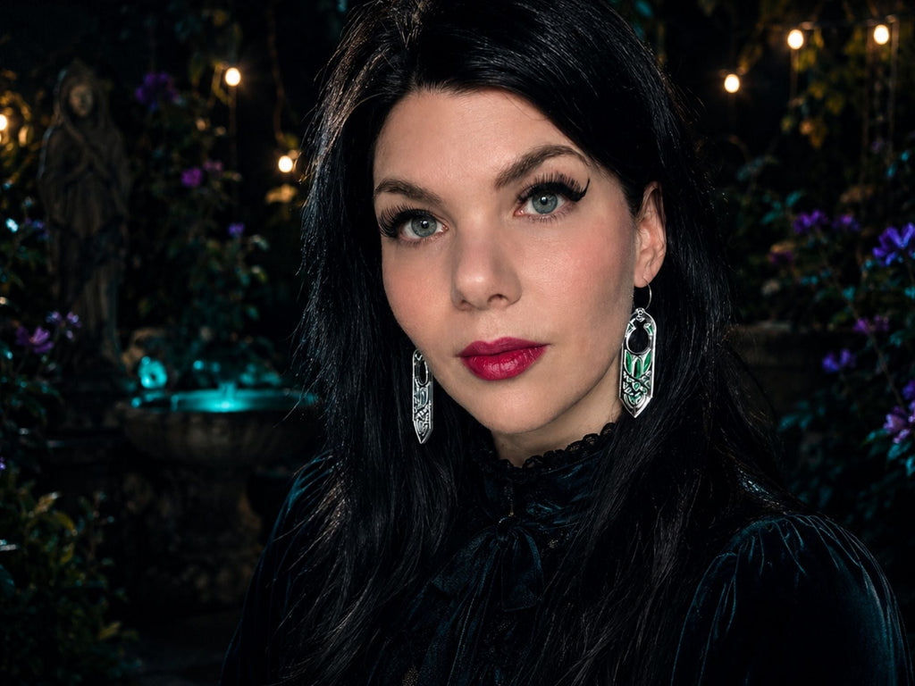 Model wearing silver Arwen fantasy statement earrings against dark atmospheric background