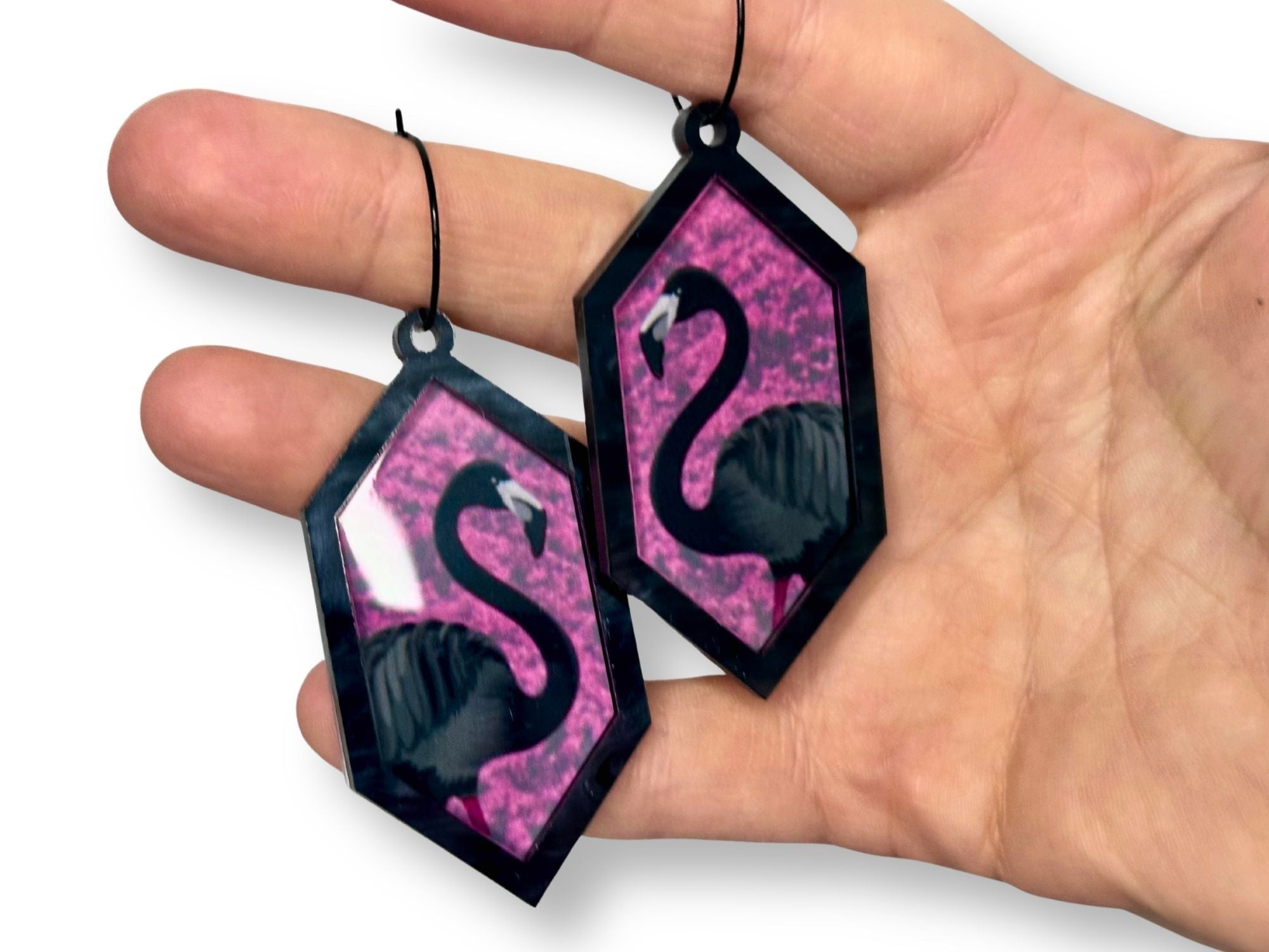 Arcadia Pink flamingo hexagon earrings shown in hand for size reference