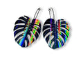 Black rainbow iridescent monstera leaf dangle earrings on black hoop ear wires.