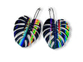 Black rainbow iridescent monstera leaf dangle earrings on black hoop ear wires.