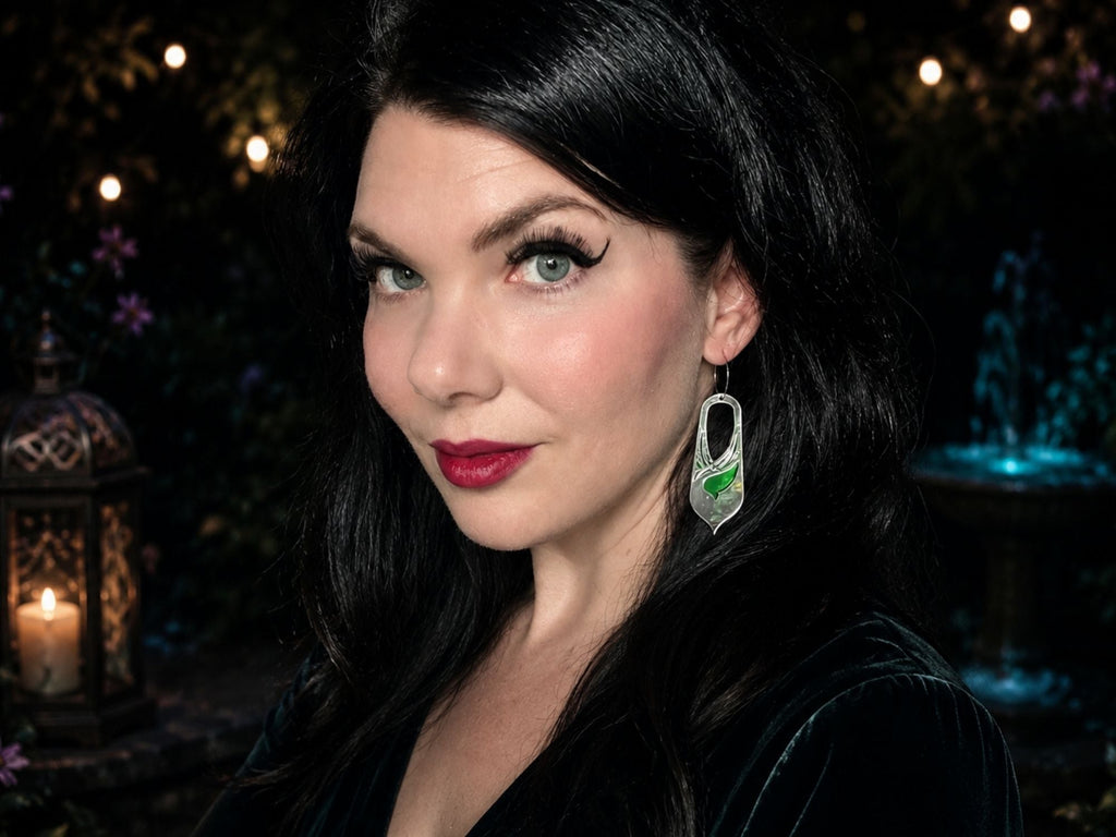 Model wearing silver mirror Bronwyn fantasy statement earrings against dark atmospheric background