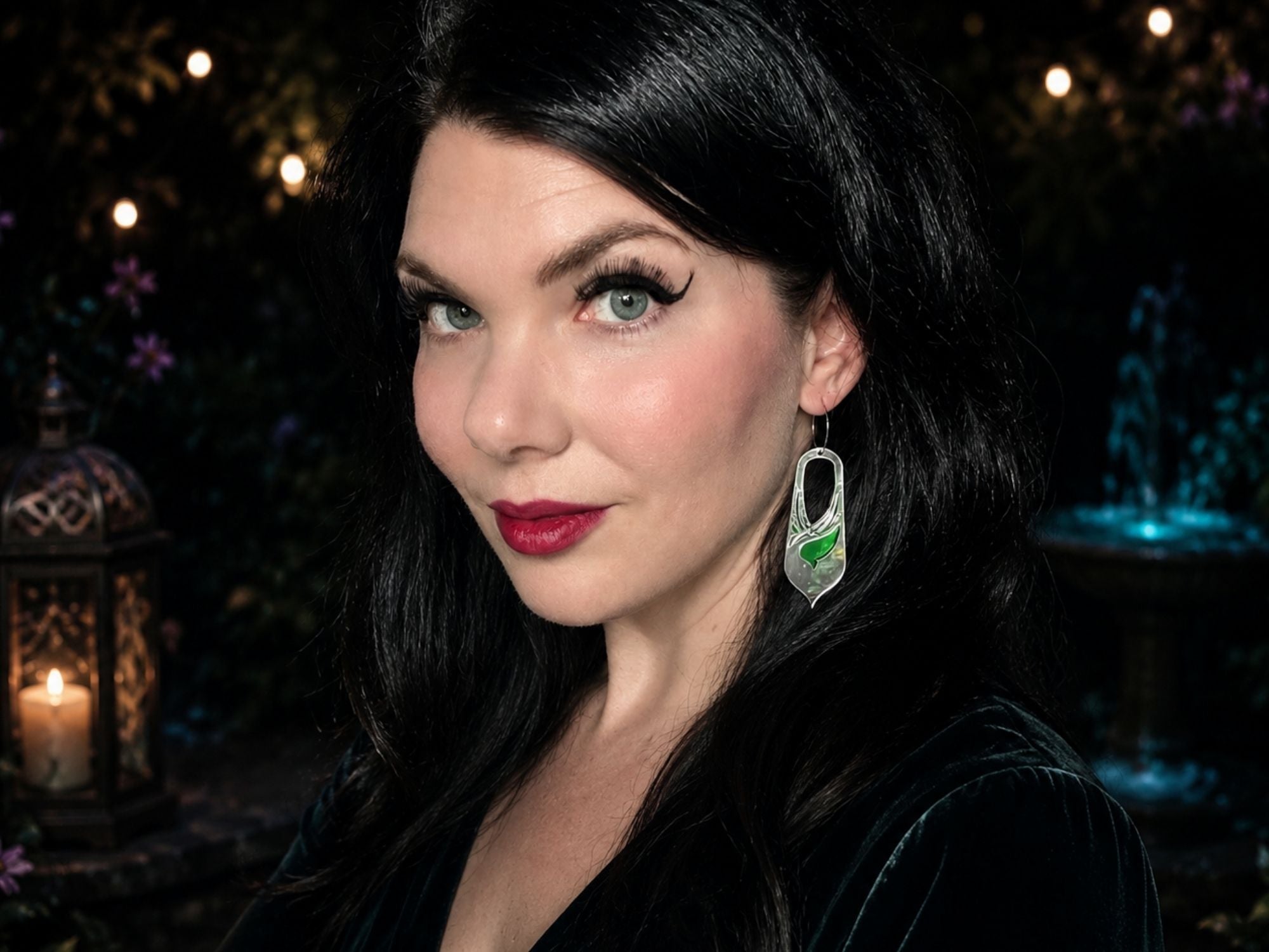 Model wearing silver mirror Bronwyn fantasy statement earrings against dark atmospheric background