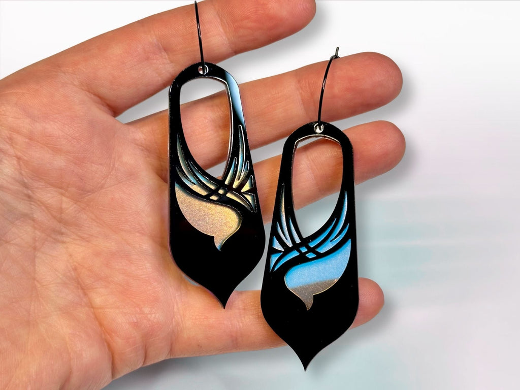 Hand holding black and iridescent Bronwyn statement earrings for size reference