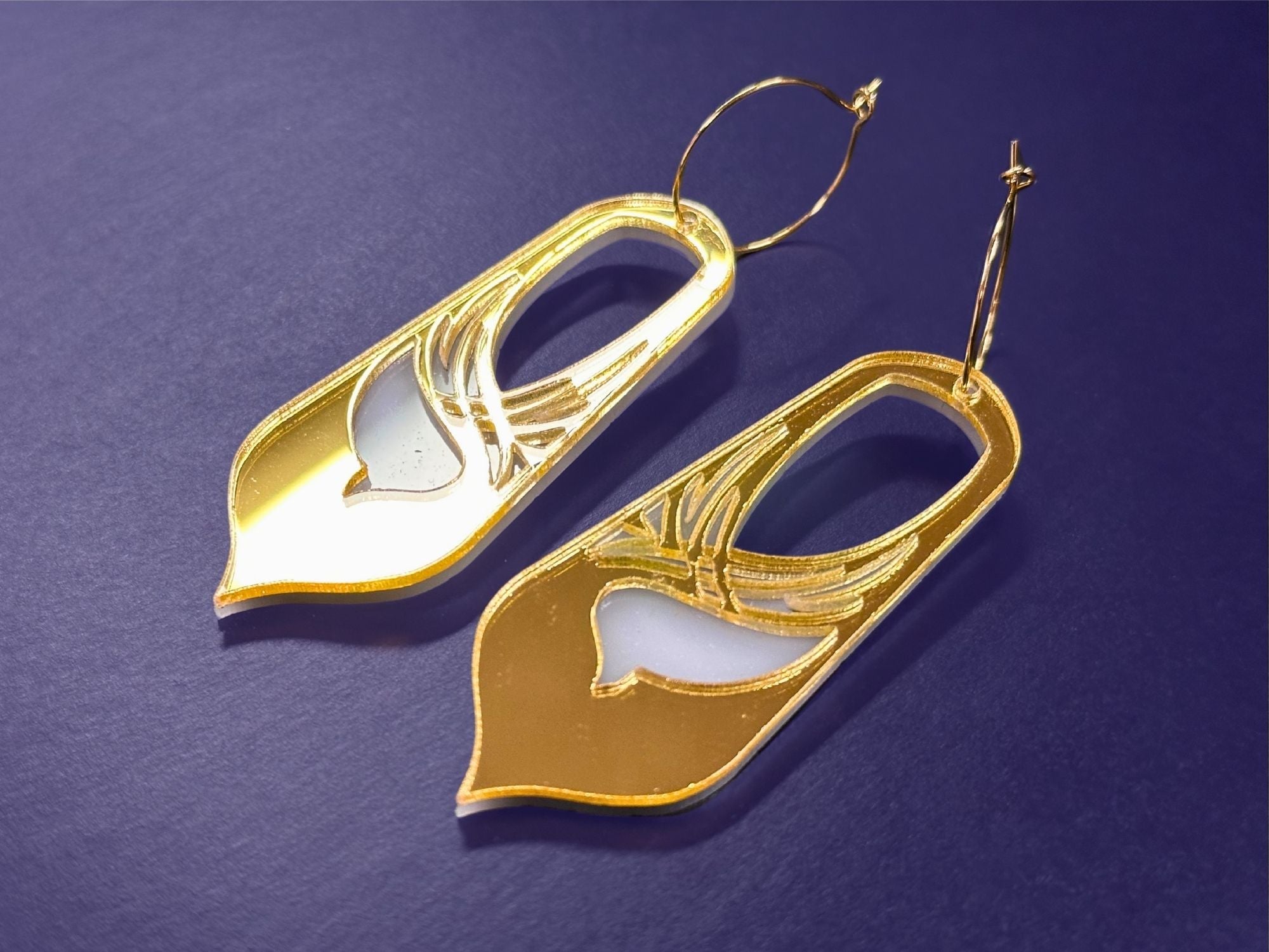 Gold mirror Sunforged Bronwyn statement earrings photographed on deep purple background