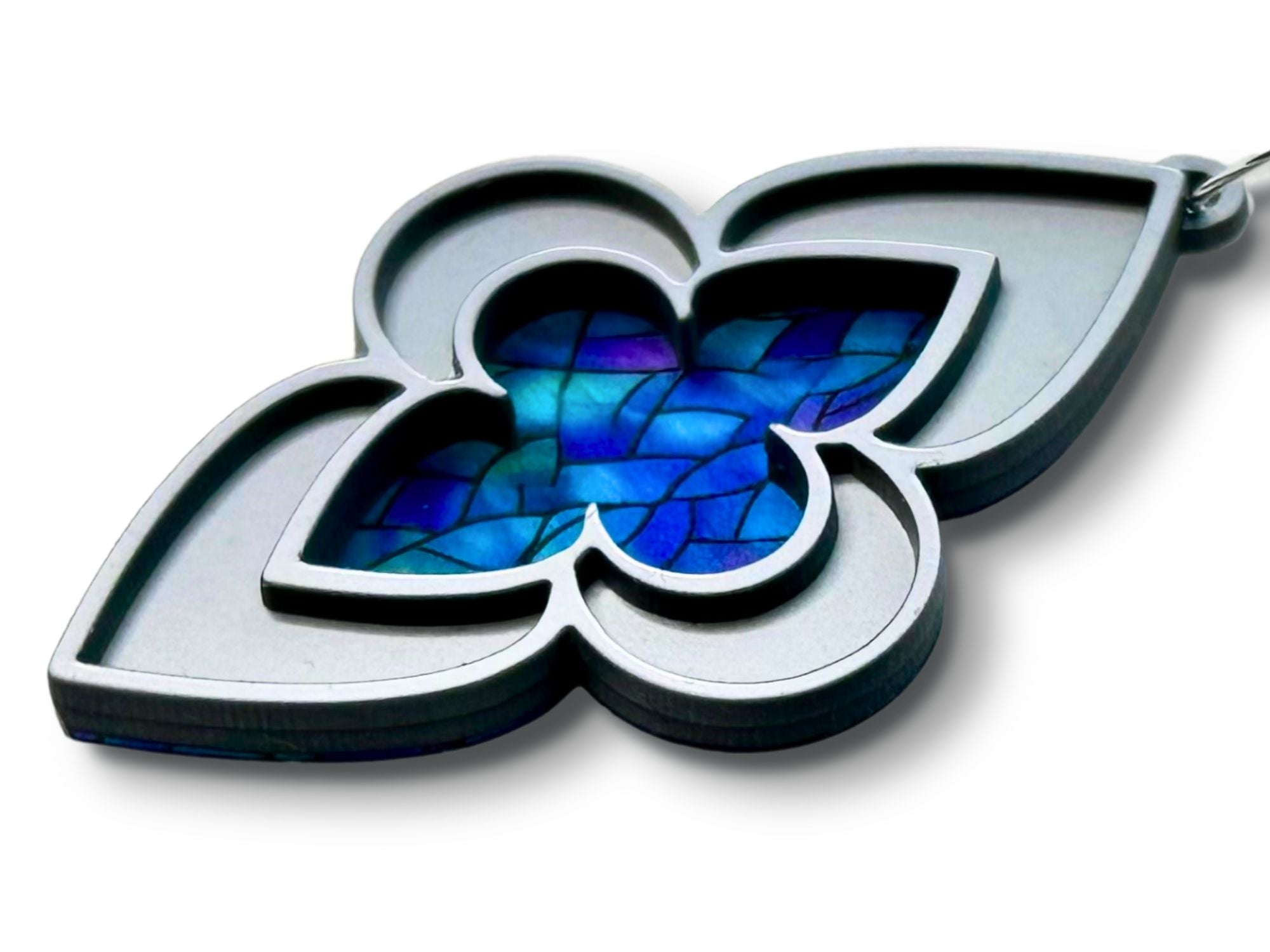 Close-up angled view of silver cathedral earrings with blue stained glass artwork