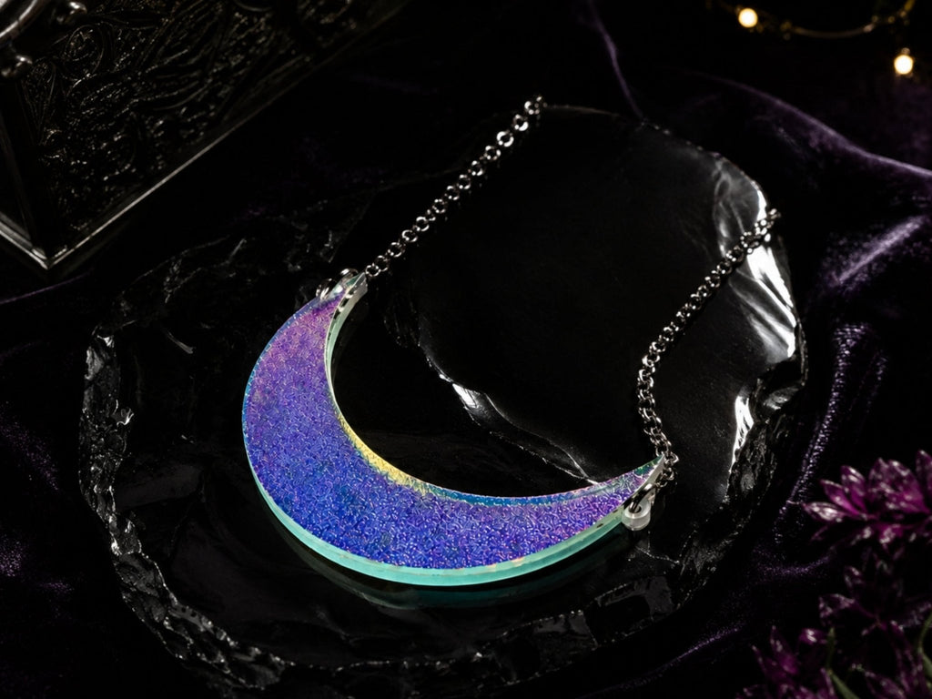 Textured iridescent crescent moon necklace displayed on black and purple background