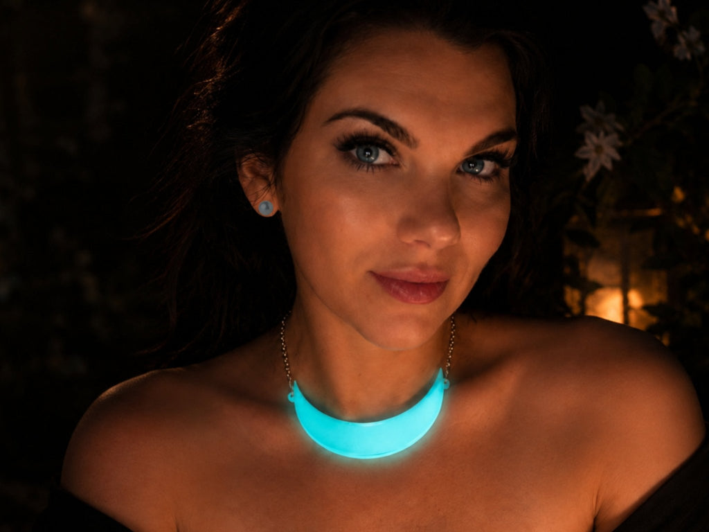 Model wearing glow-in-the-dark iridescent crescent moon statement collar necklace at night
