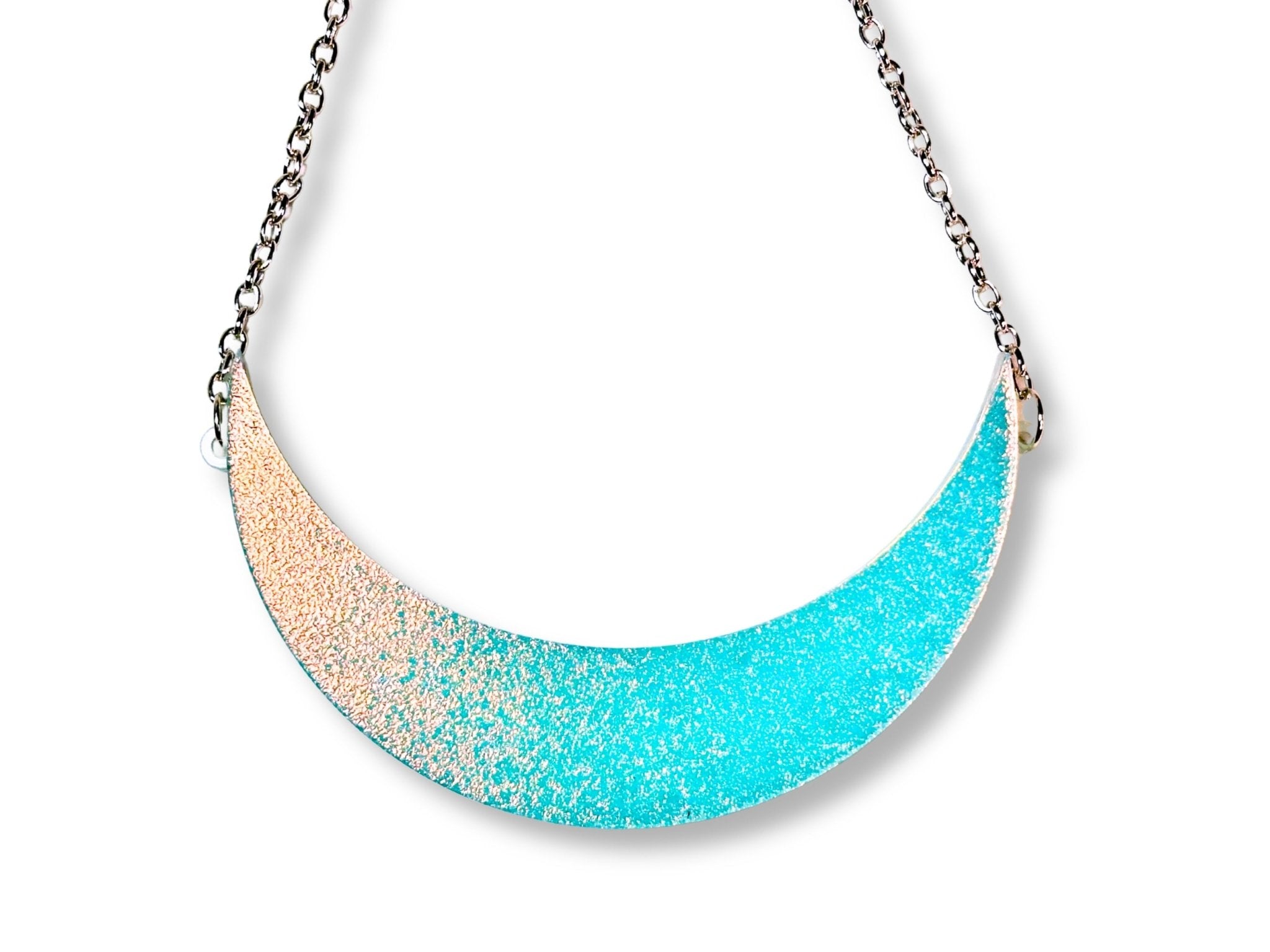 Iridescent glow-in-the-dark crescent moon collar necklace on white background