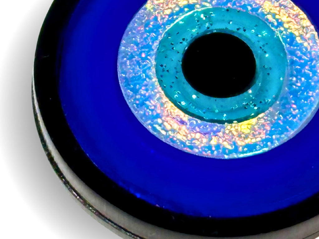 close up of evil eye jewelry set showing layered acrylic detail iridescent and textured finishes blue black