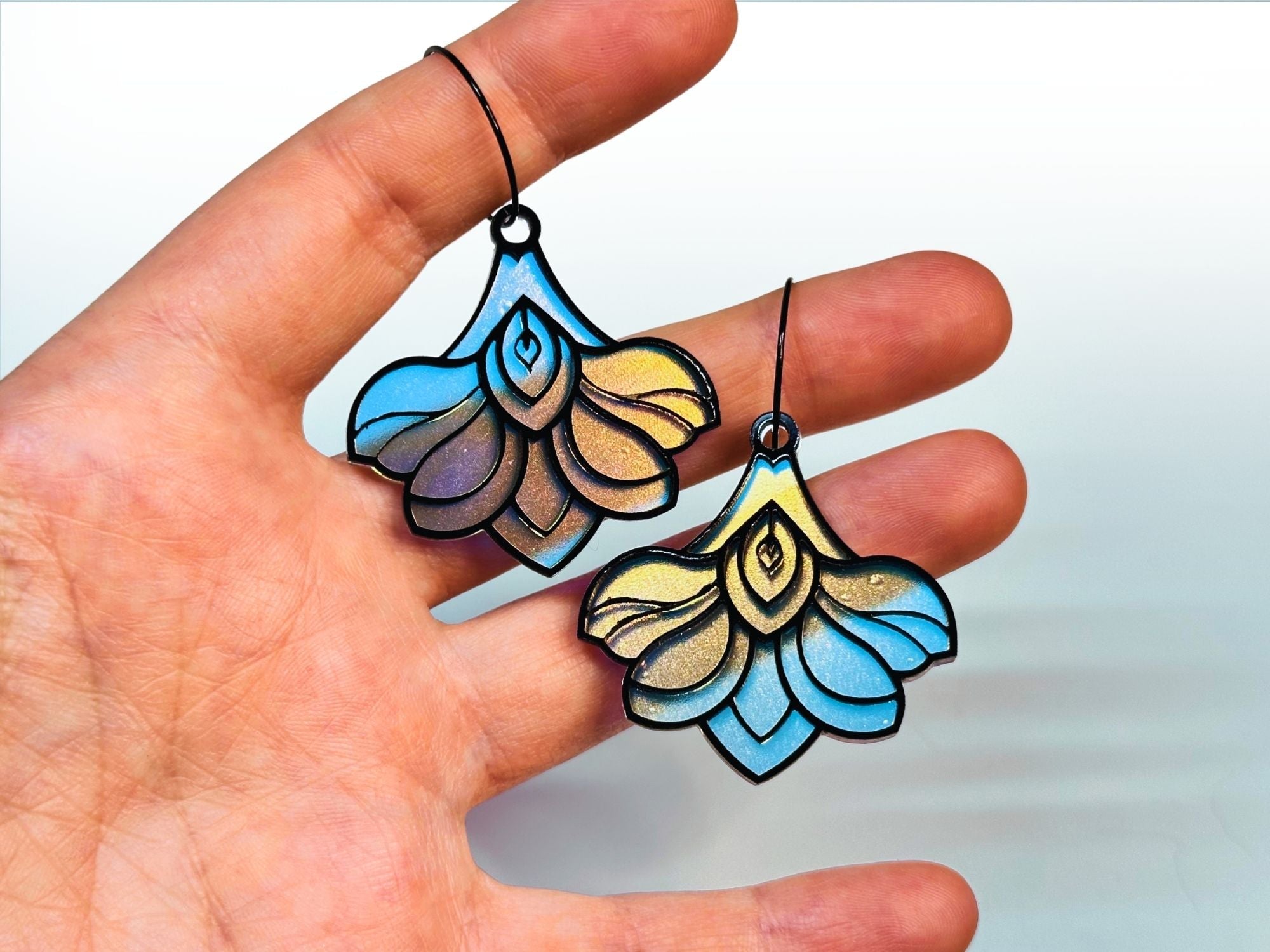 Hand holding Deco Bloom earrings showing size and scale