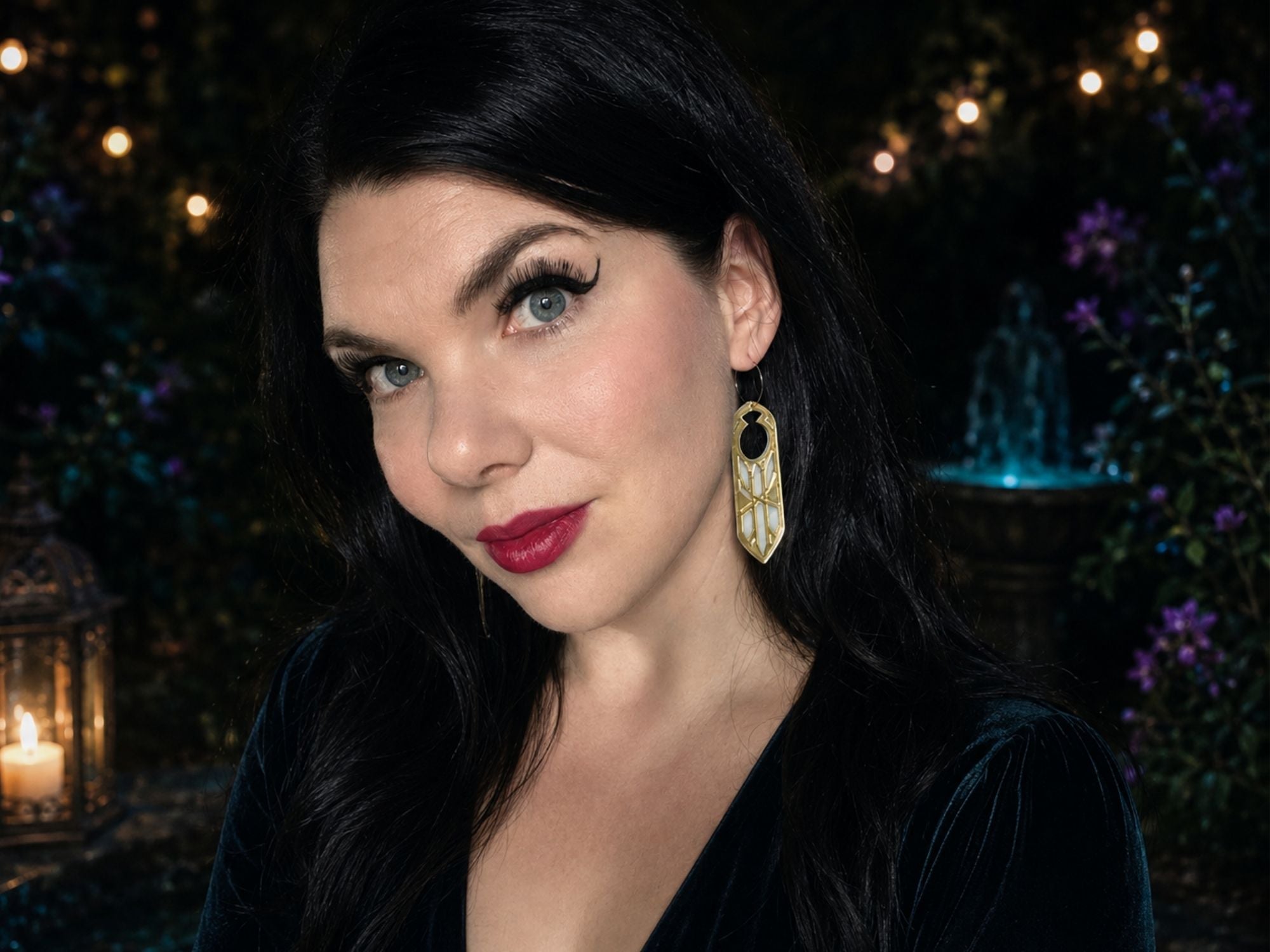 Model wearing gold mirror Disa fantasy statement earrings against dark atmospheric background