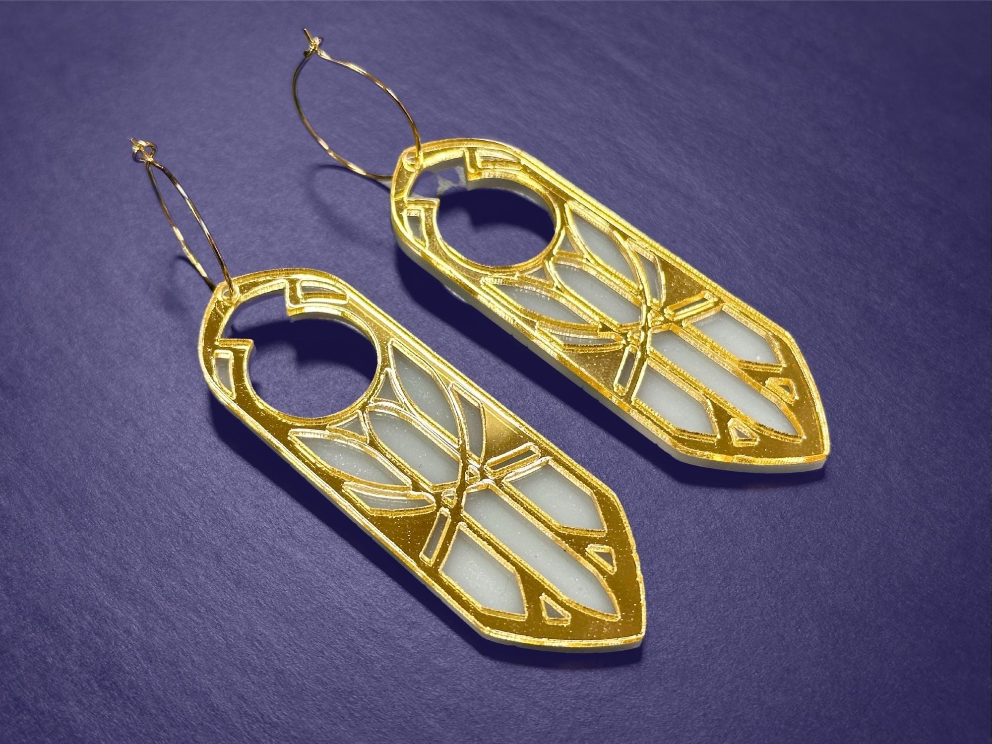 Gold mirror Sunforged Disa statement earrings photographed on deep purple background