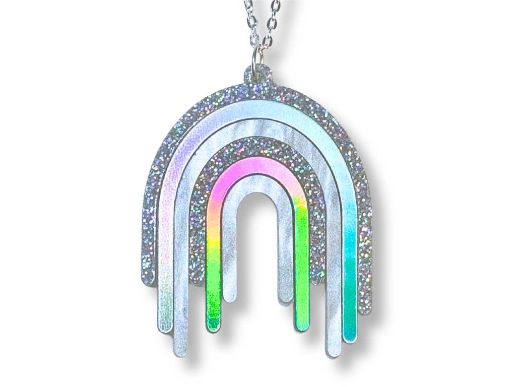 Disco Prism drip pendant necklace with layered silver, holographic glitter and iridescent rainbow arcs on a white background.