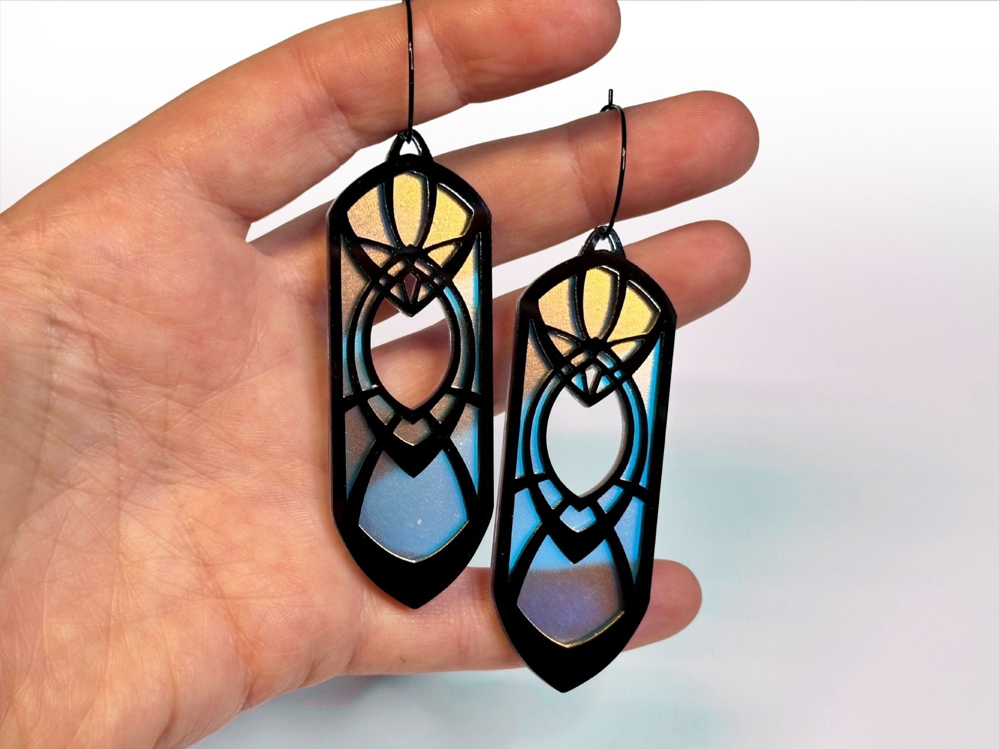 Hand holding black iridescent Obsidian Eowyn earrings for size reference