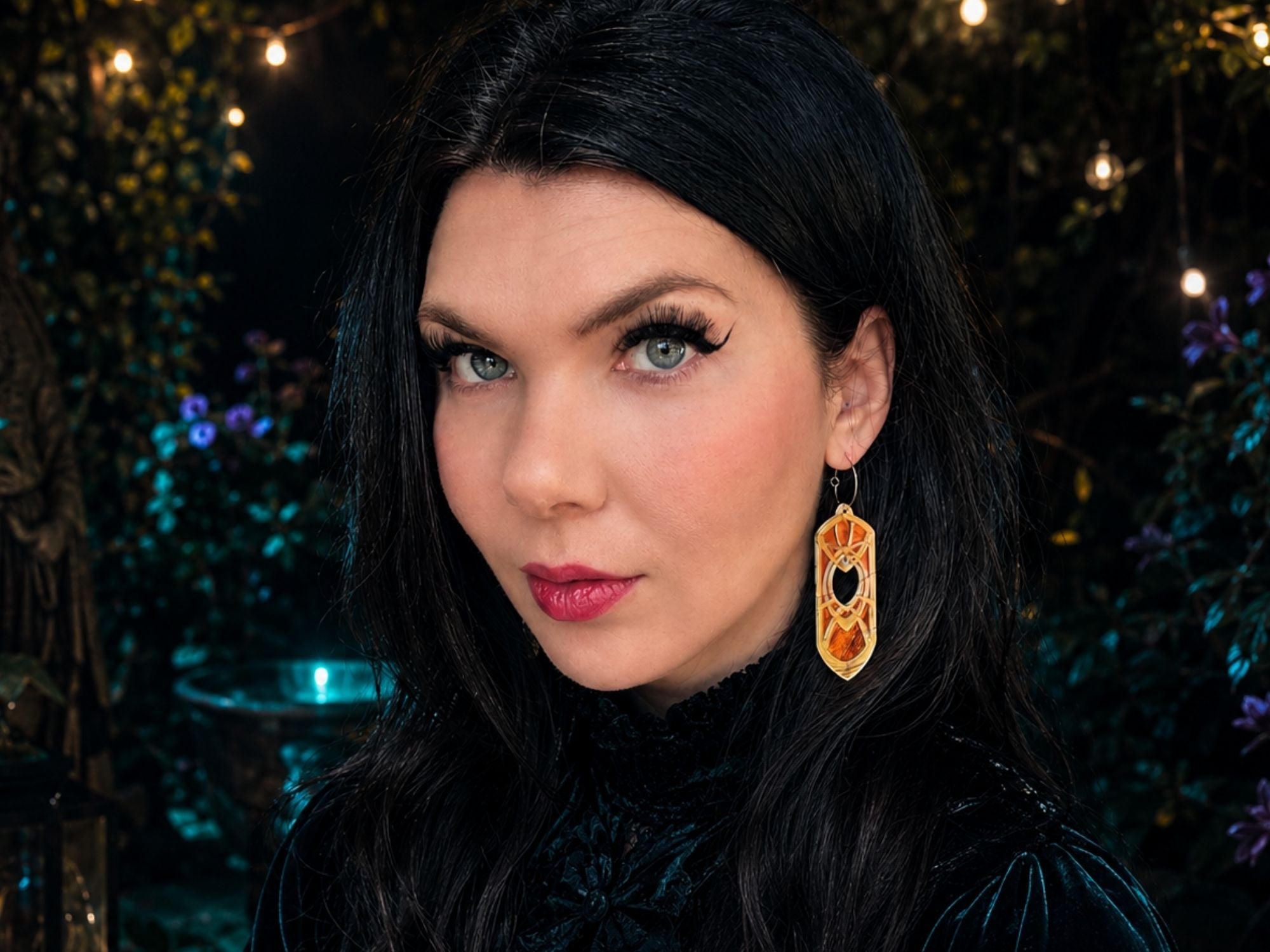 Model wearing moonglass Eowyn fantasy earrings against dark glittering background
