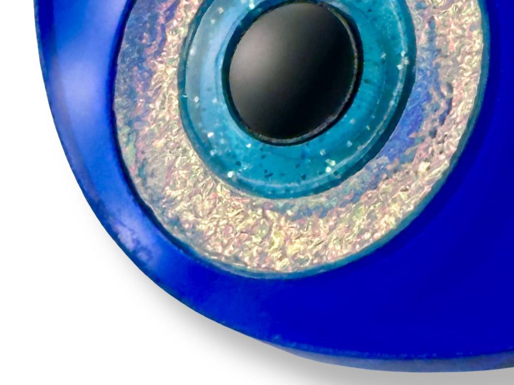 close up of evil eye statement earrings showing layered acrylic detail iridescent and textured finishes macro