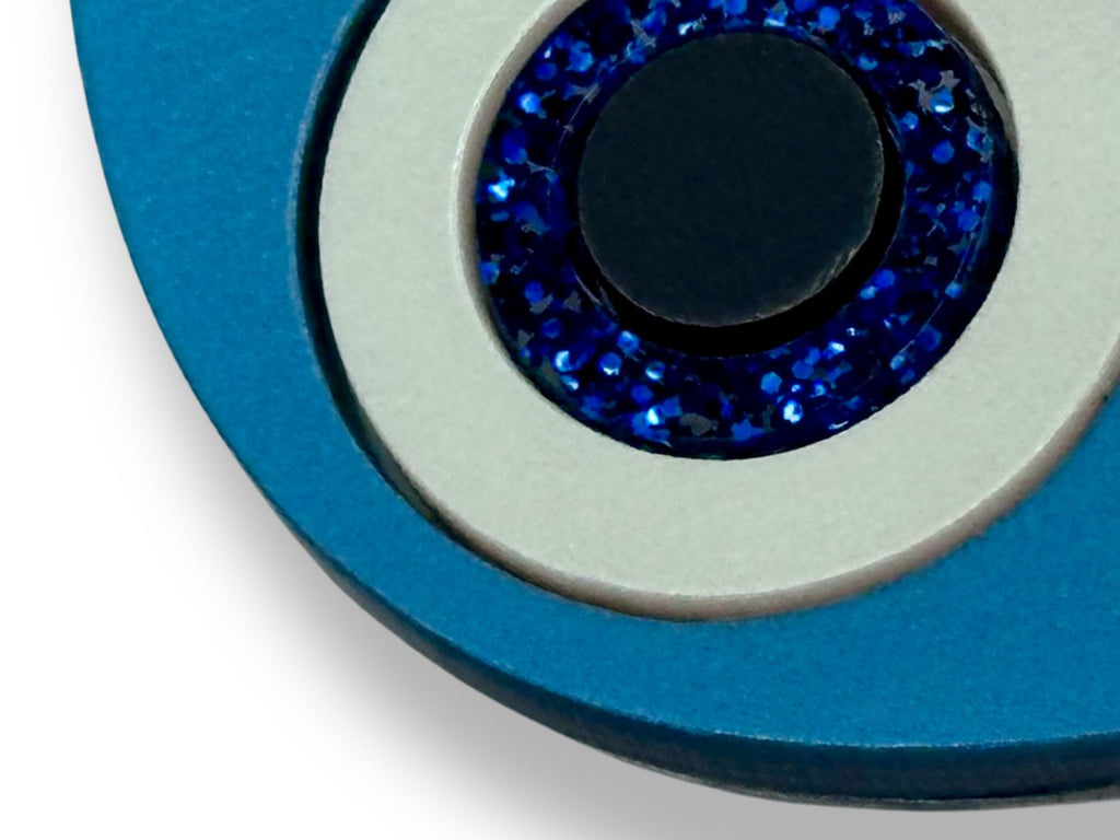 close up of evil eye statement earrings showing layered acrylic detail metallic glitter and textured finishes blue white black macro
