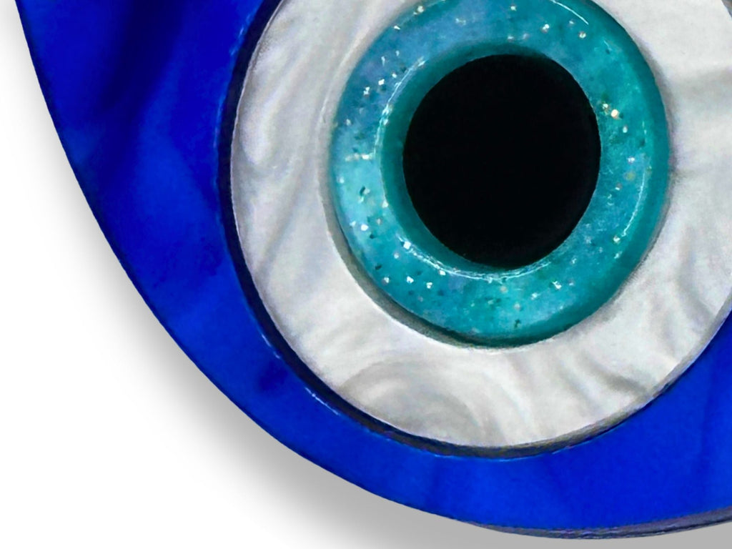 layered construction of evil eye earrings showing dimensional acrylic design and engraved detail blue white black