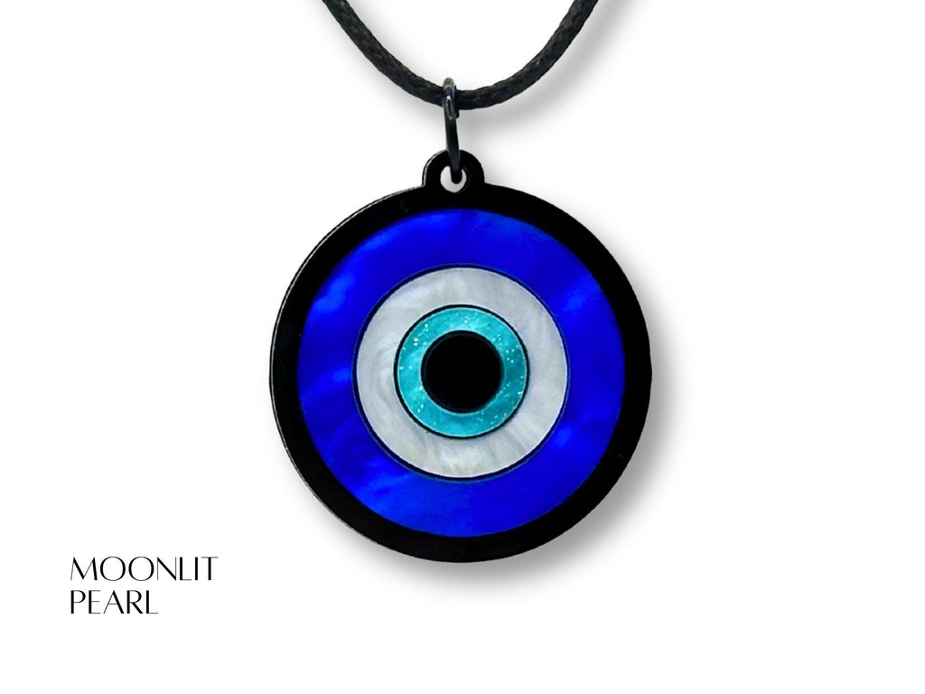 evil eye pendant necklace styled flatlay iridescent acrylic talisman jewelry minimal aesthetic blue white black