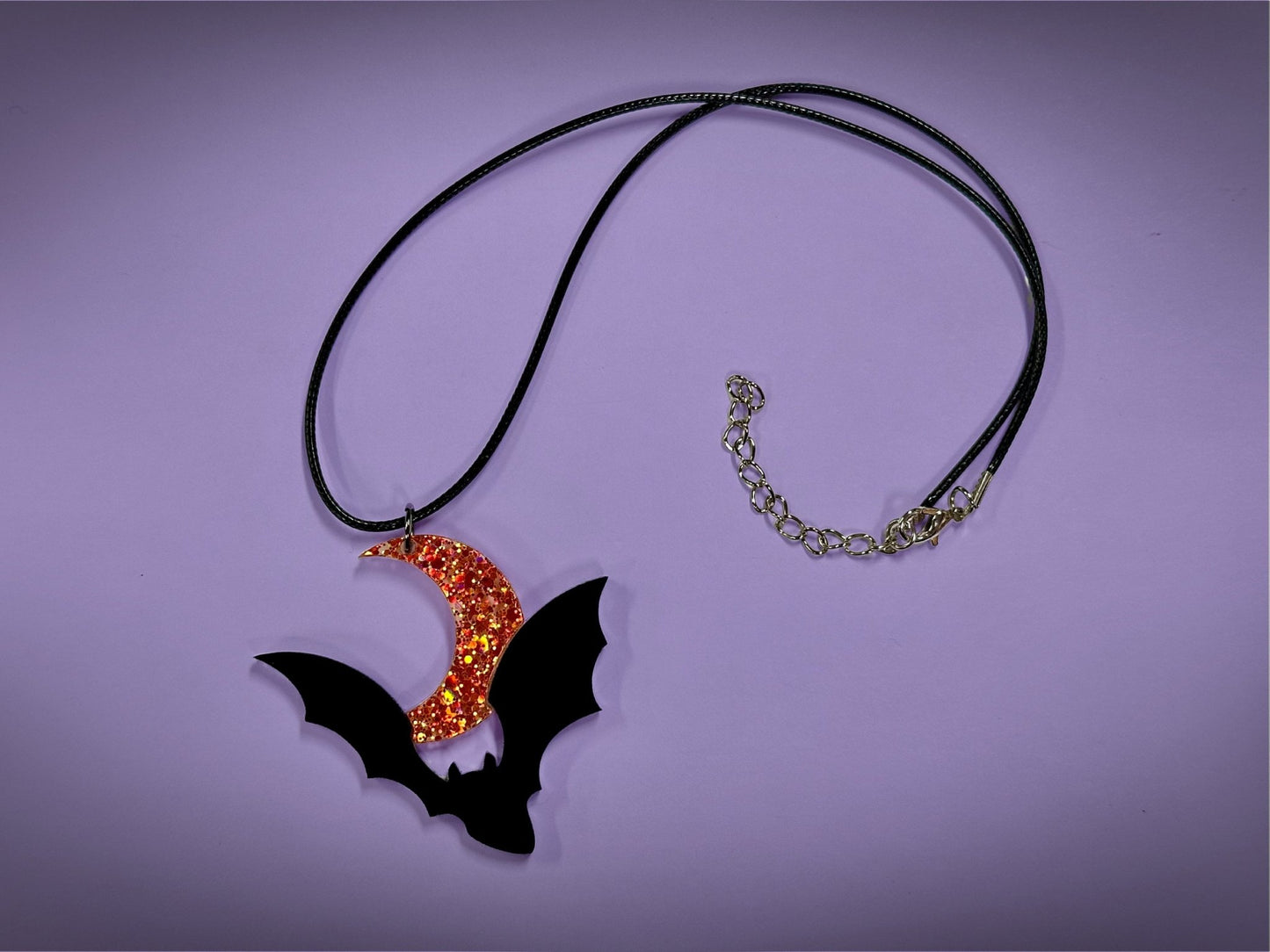 Flying Bat and Crescent Moon Pendant | Black and Holographic Harvest Orange Glitter Halloween Necklace - Painted Raina