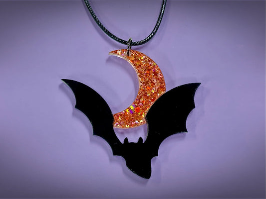 Flying Bat and Crescent Moon Pendant | Black and Holographic Harvest Orange Glitter Halloween Necklace - Painted Raina