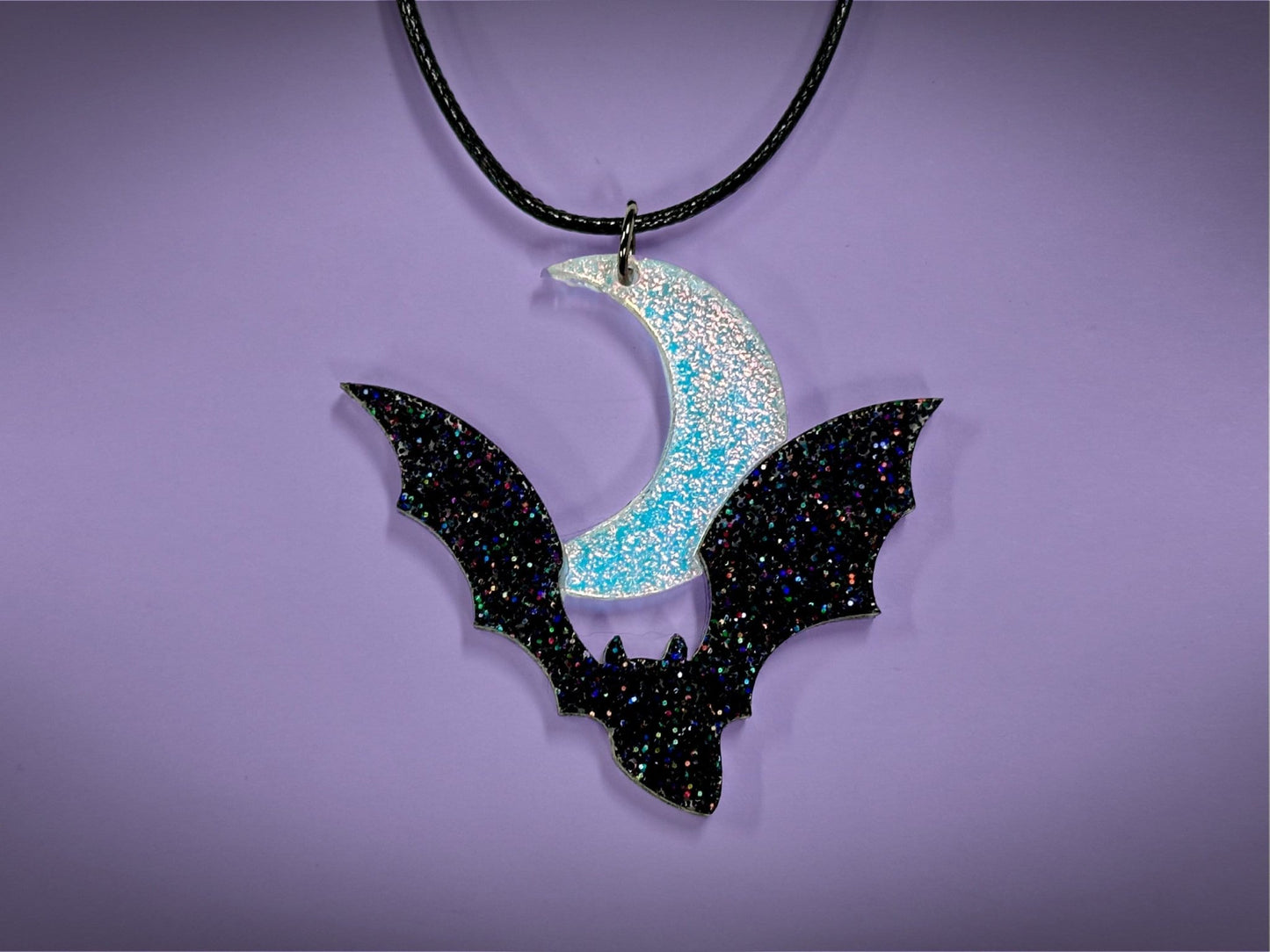 Flying Bat and Crescent Moon Pendant | Black Rainbow Holographic Glitter & Textured Iridescent Halloween Necklace - Painted Raina