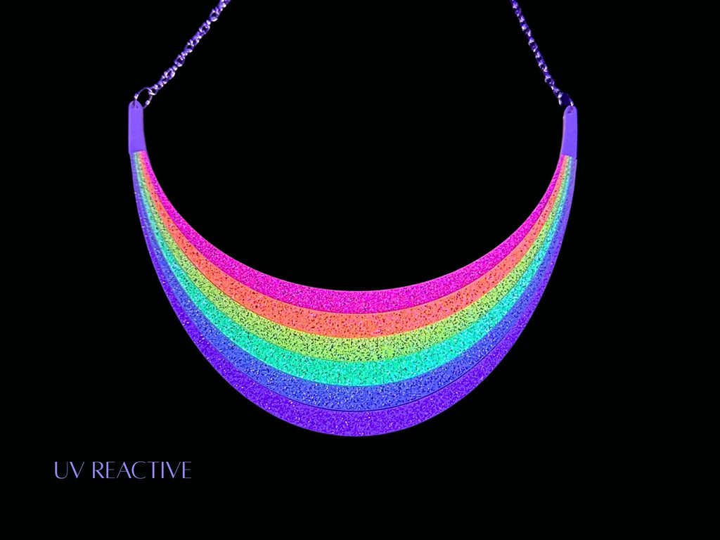 UV-reactive Full Spectrum Rebel Rainbow Rave arc necklace editorial product image on black background.