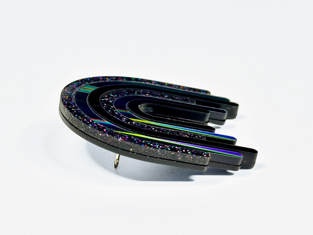 Side angle view of layered black rainbow acrylic brooch