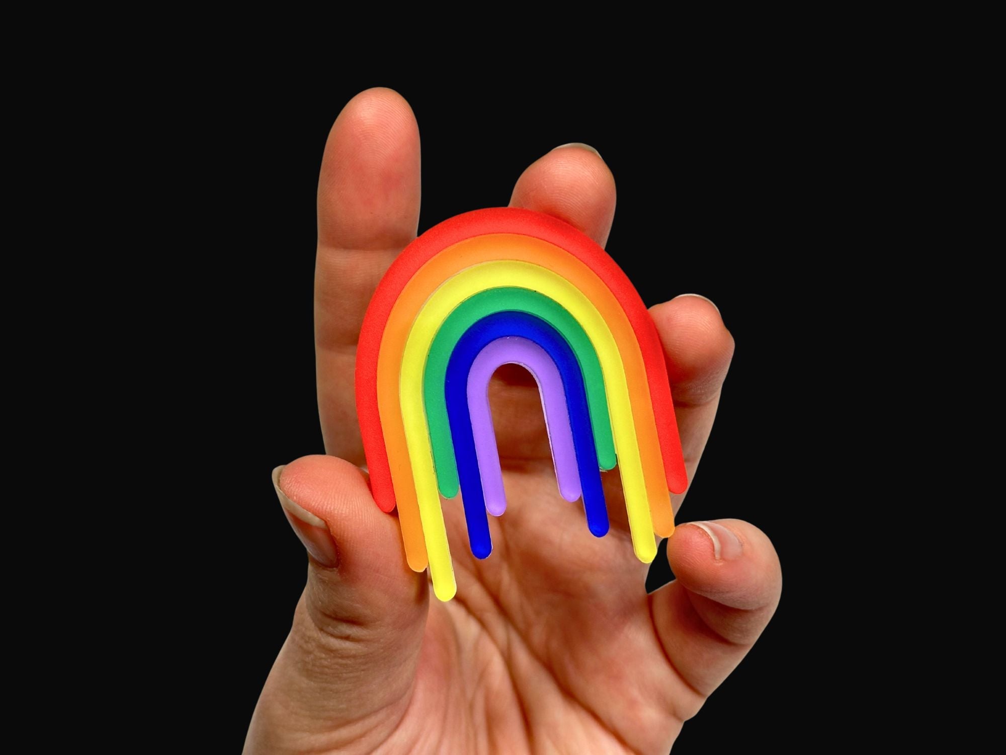 Hand holding Full Spectrum Rebel Drip Brooch for scale