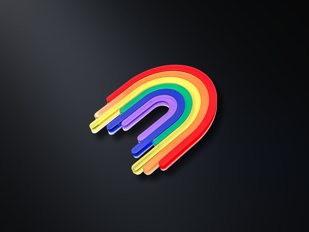 Rainbow acrylic drip brooch photographed on dark background