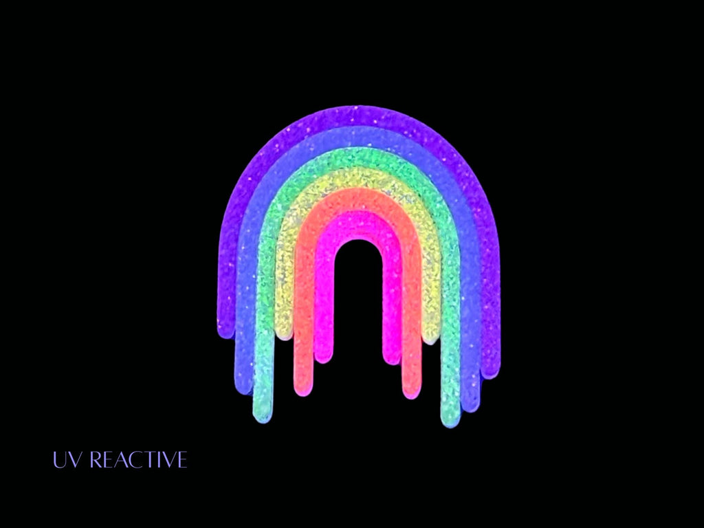 UV reactive Full Spectrum Rebel Rainbow Rave drip brooch editorial product image on black background.