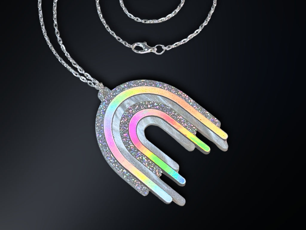 Disco Prism rainbow drip pendant necklace with layered silver, holographic glitter and iridescent arcs on a stainless steel chain.