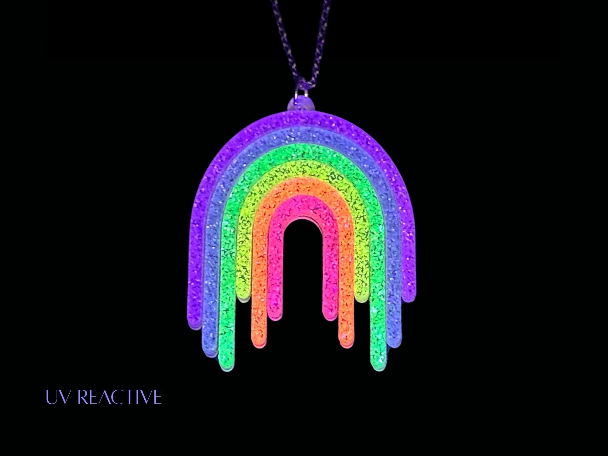 UV reactive Full Spectrum Rebel Rainbow Rave drip pendant editorial product image on black background.