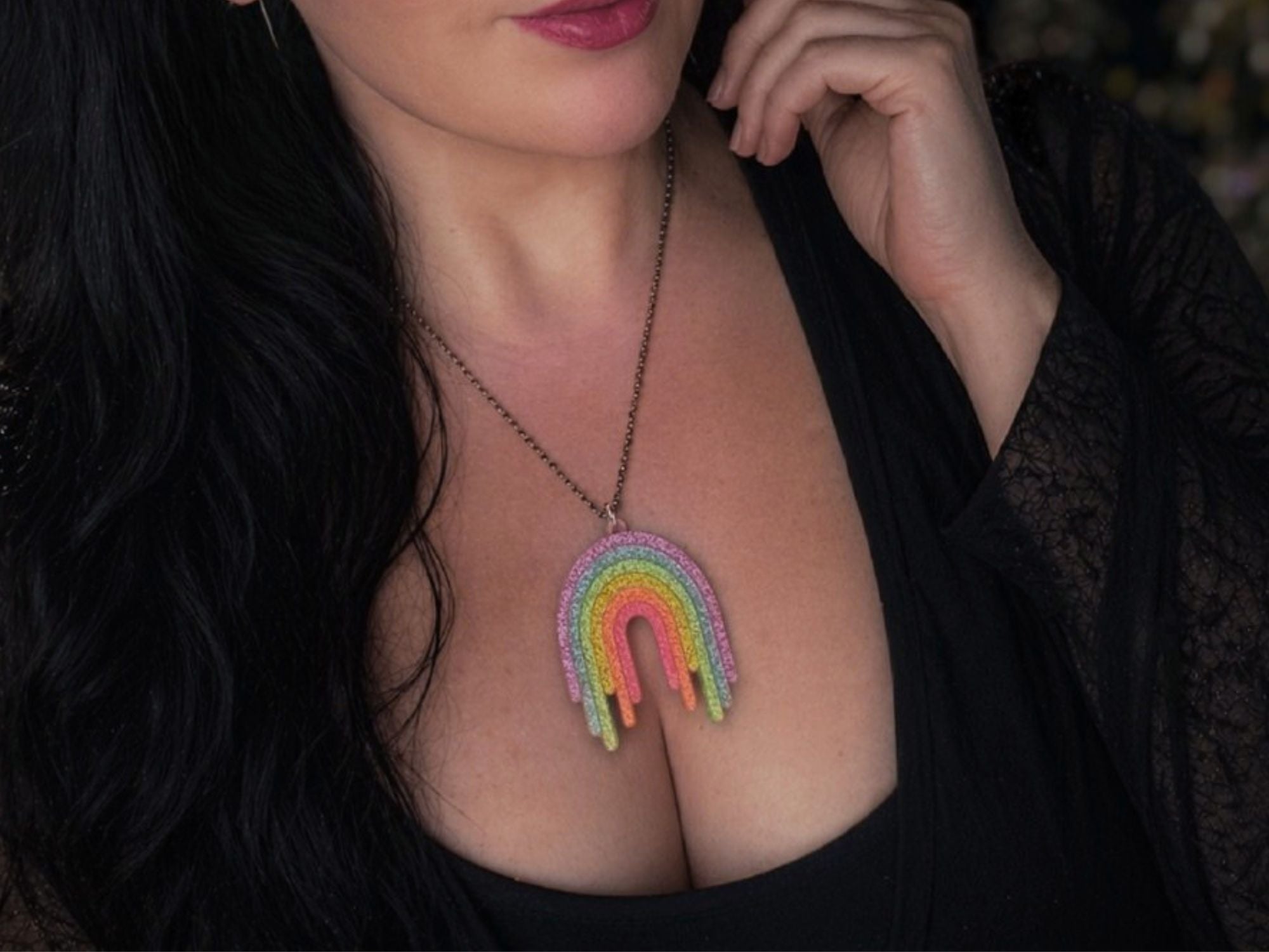 Model wearing Full Spectrum Rebel Rainbow Rave drip pendant necklace in glitter acrylic.