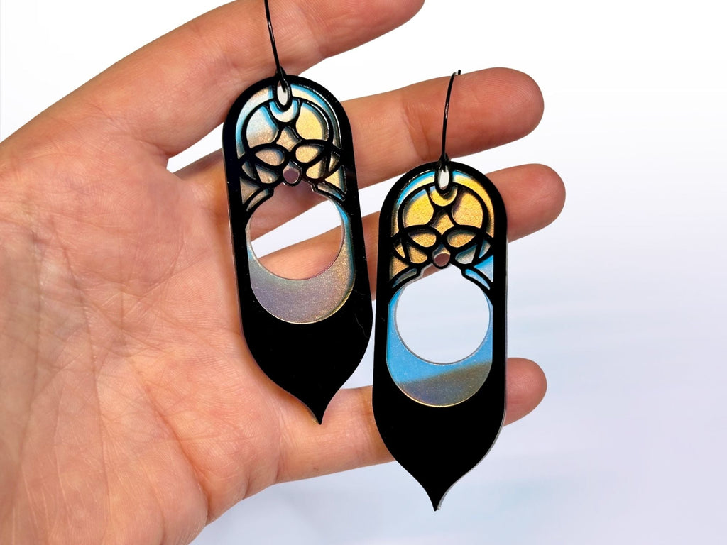 Hand holding black and iridescent Galadriel statement earrings for size reference