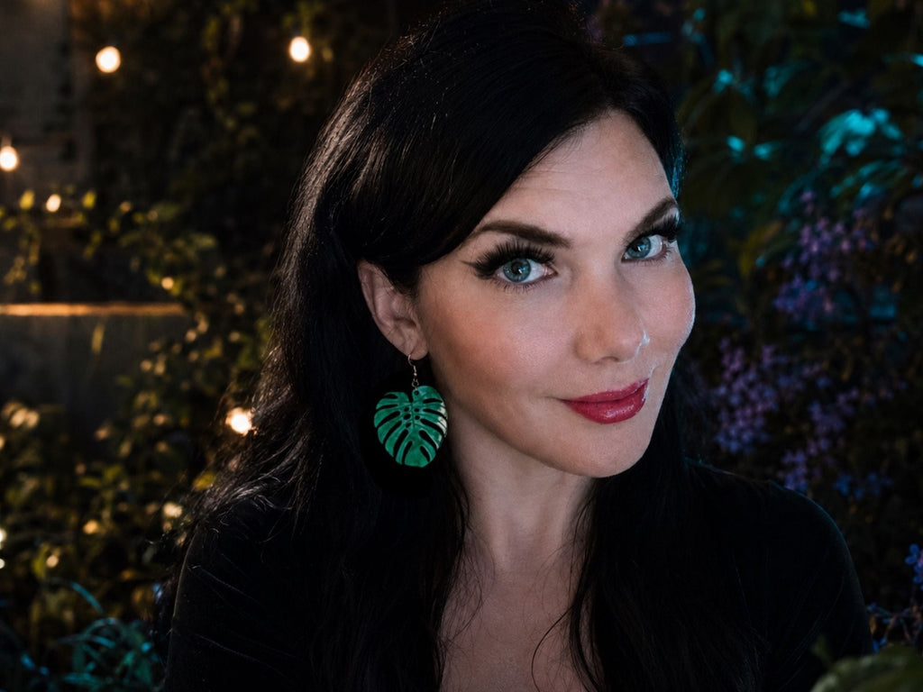 Woman wearing Verdant Pearl monstera leaf statement earrings for size reference and styling inspiration.