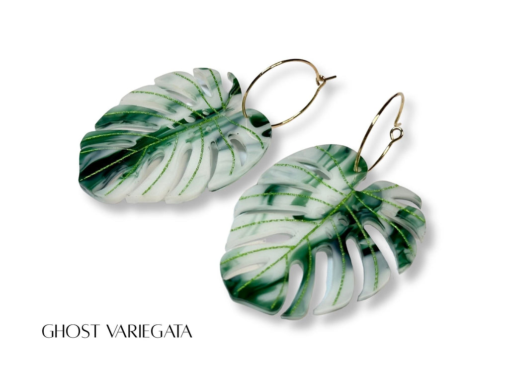 Ghost Variegata monstera leaf earrings in white and green marble acrylic with engraved vein details.