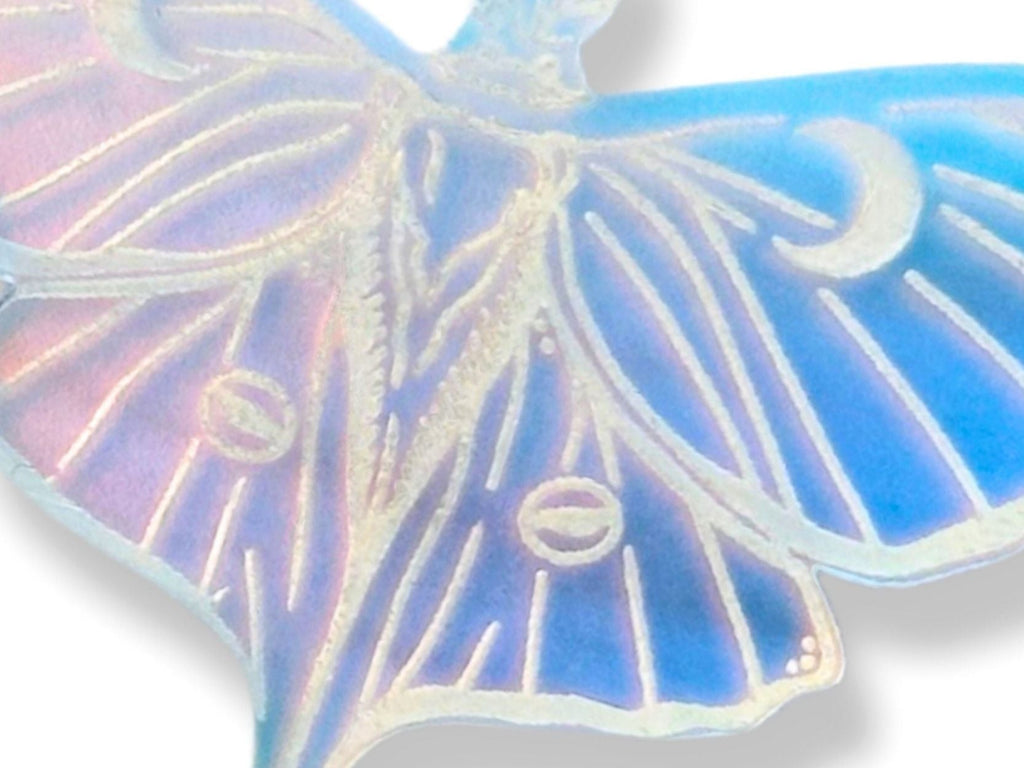 close up of iridescent luna moth earrings showing color shifting acrylic and luminous surface detail