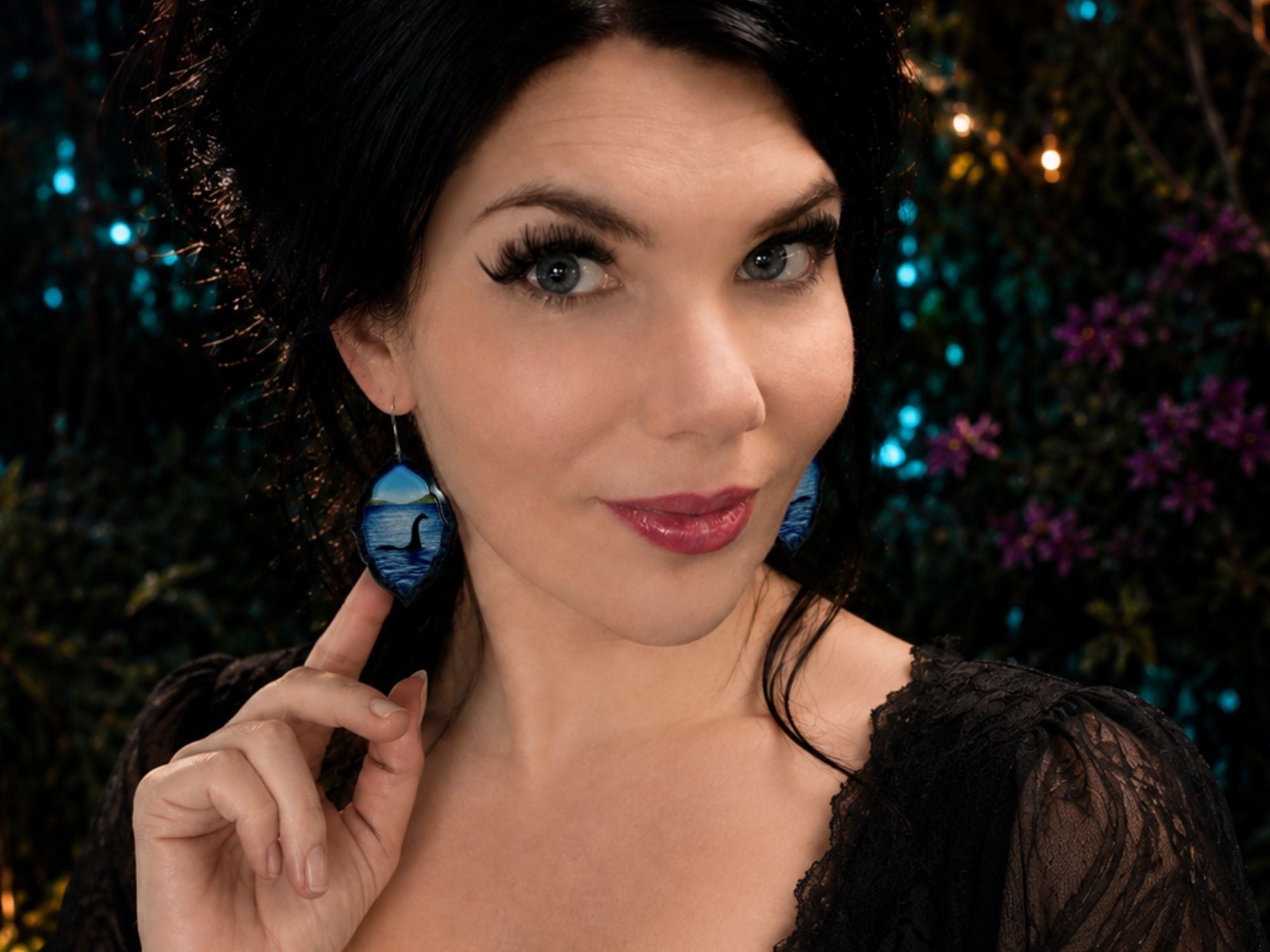 Model wearing Loch Ness monster lake scene earrings in layered acrylic.