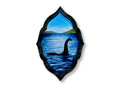 Original Loch Ness Monster brooch featuring blue lake artwork framed in black pearl acrylic.
