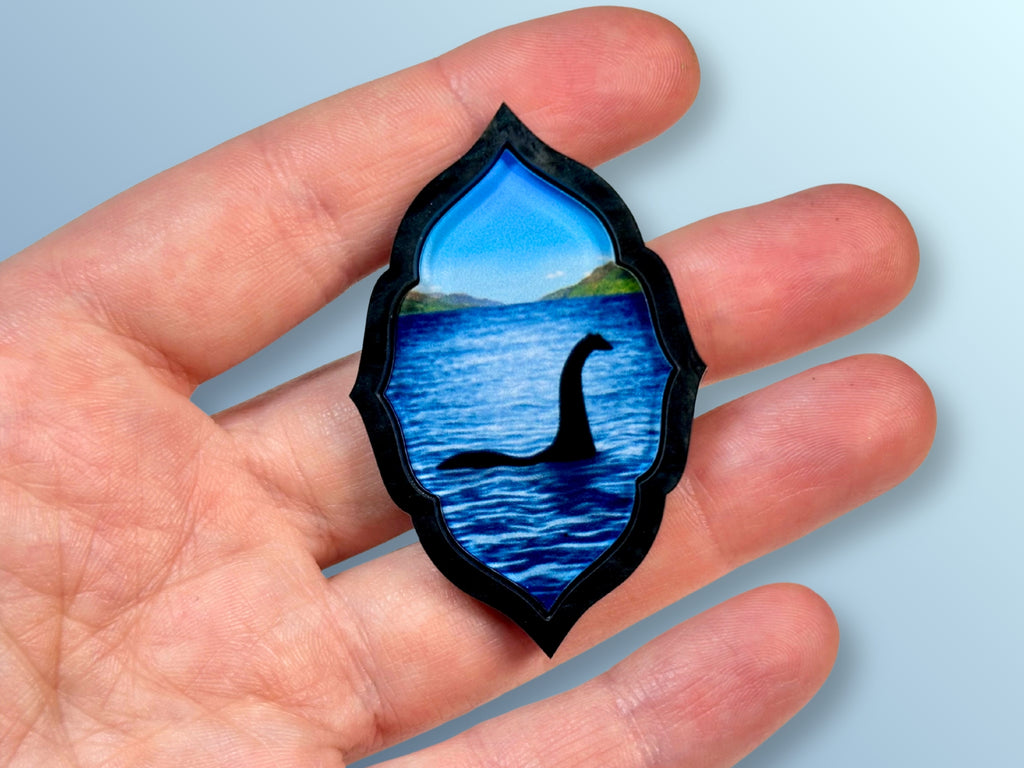 Loch Ness Monster brooch shown in hand for size reference.