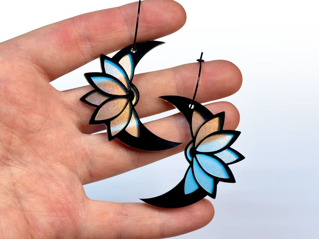 Hand holding Obsidian lotus moon earrings showing size and scale