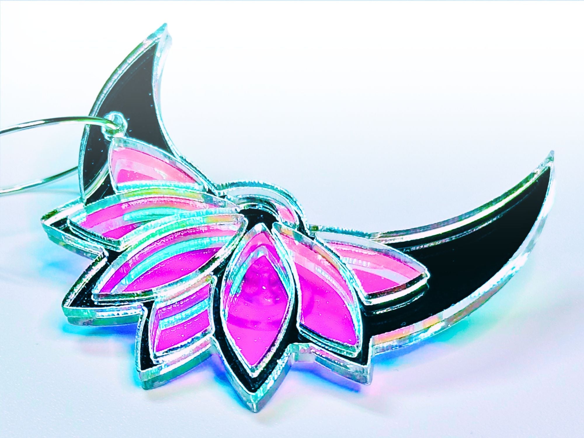 Starsteel lotus moon earring close-up showing iridescent pink and aqua details