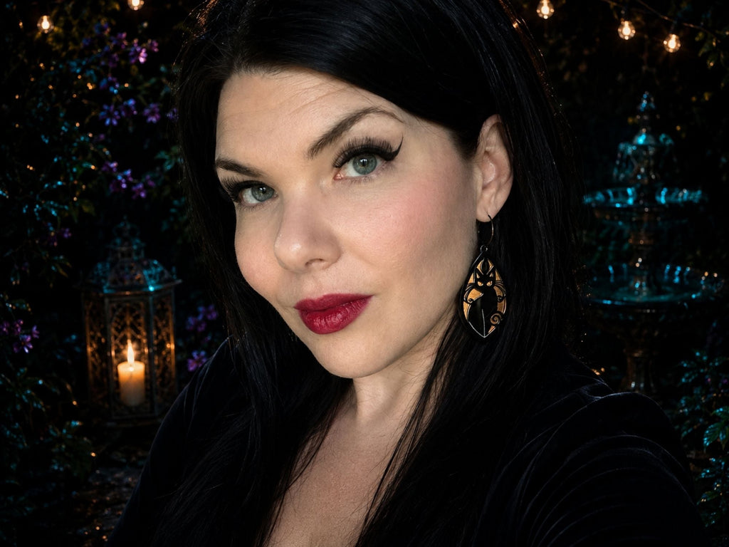 Woman wearing iridescent black cat earrings showing scale and styling