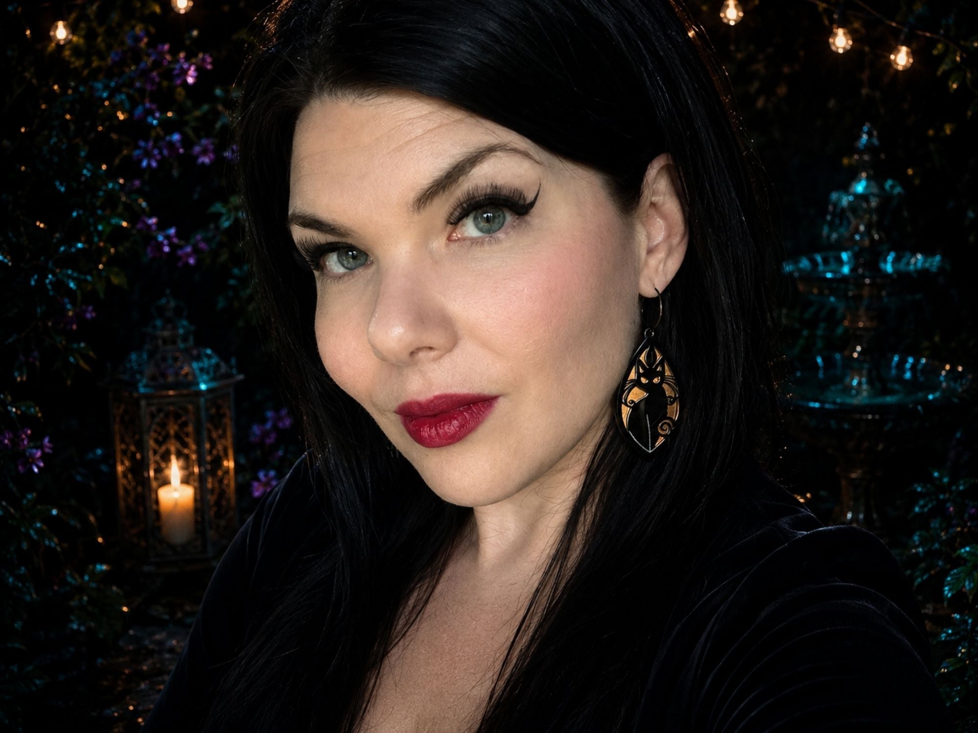 Woman wearing iridescent black cat earrings showing scale and styling