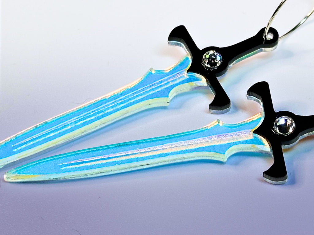 Close-up of engraved iridescent acrylic sword earrings with crystal accents