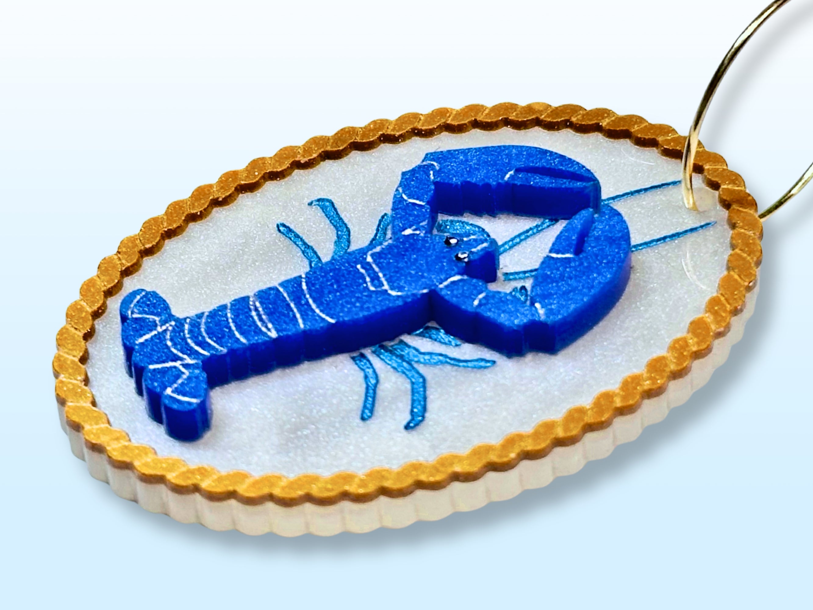 Close side view of blue lobster earring showing three-piece layered acrylic